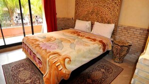 Une chambre à coucher avec un grand lit, une couvre-lit à motifs et une tête de lit décorative.