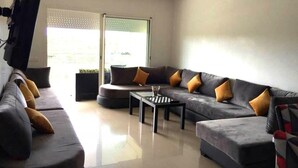A modern living room with a sectional sofa, a coffee table, and a flat-screen TV mounted on the wall. - Residence Olavonka 3364 (CASABLANCA)