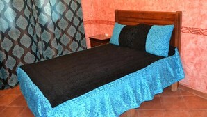 A bed with a black and blue bedspread, a wooden headboard, and two pillows. - Residence Java Rasmile Mdiq 3396 (Mdiq)