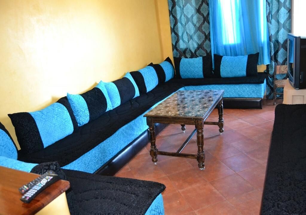A living room with a sofa set, a coffee table, and a television.