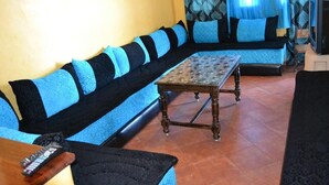 A living room with a sofa set, a coffee table, and a television. - Residence Java Rasmile Mdiq 3396 (Mdiq)