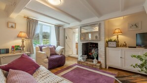 A cozy living room with a fireplace, comfortable seating, and a television. - First & Last, Trimingham, Norfolk (Trimingham)