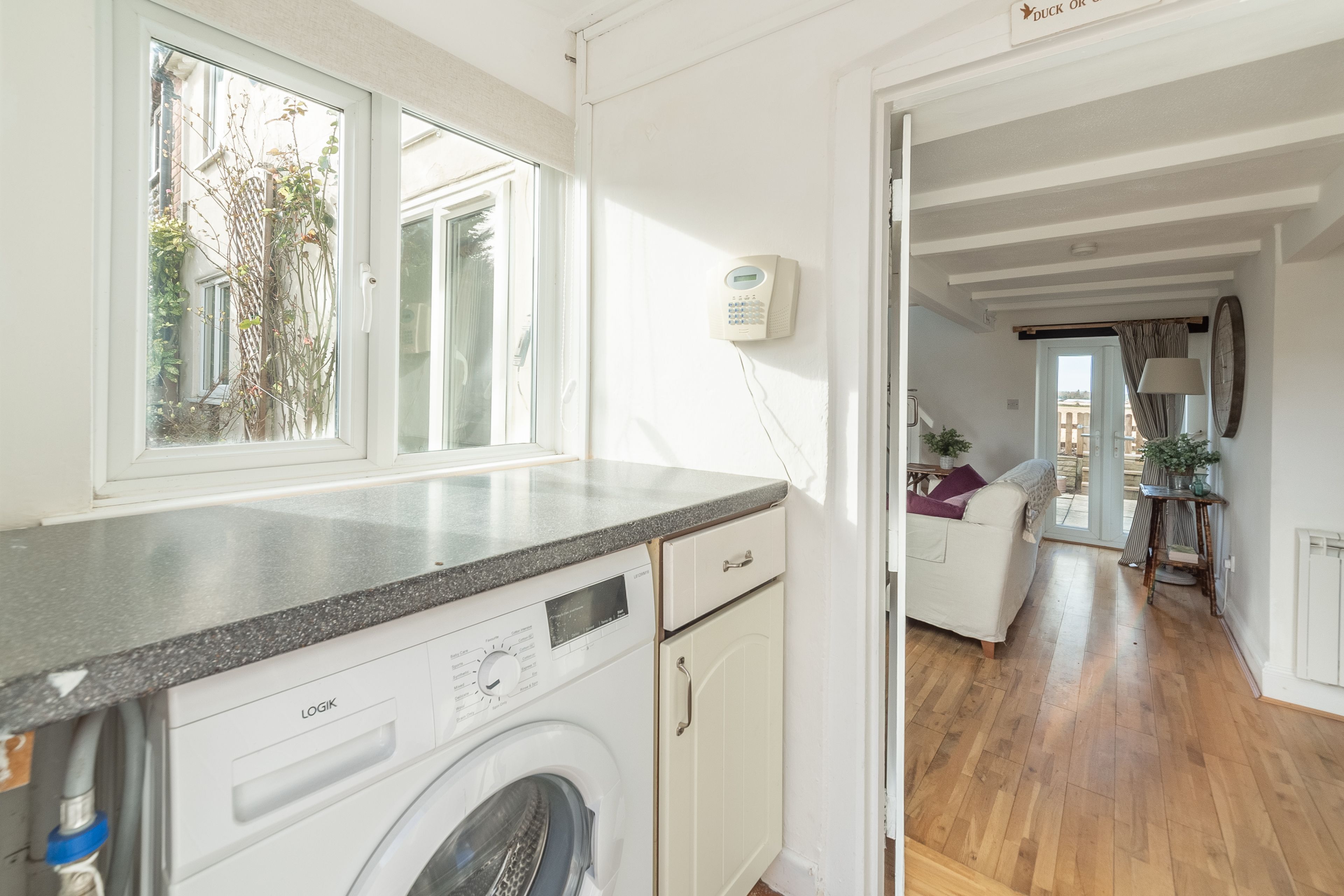 Une cuisine équipée d’un lave-linge, d’une fenêtre et offrant une vue sur l’extérieur.