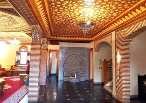 An interior with a patterned ceiling, a chandelier, and a large decorative wall. - Villa Amerchich 2968 (Marrakech)