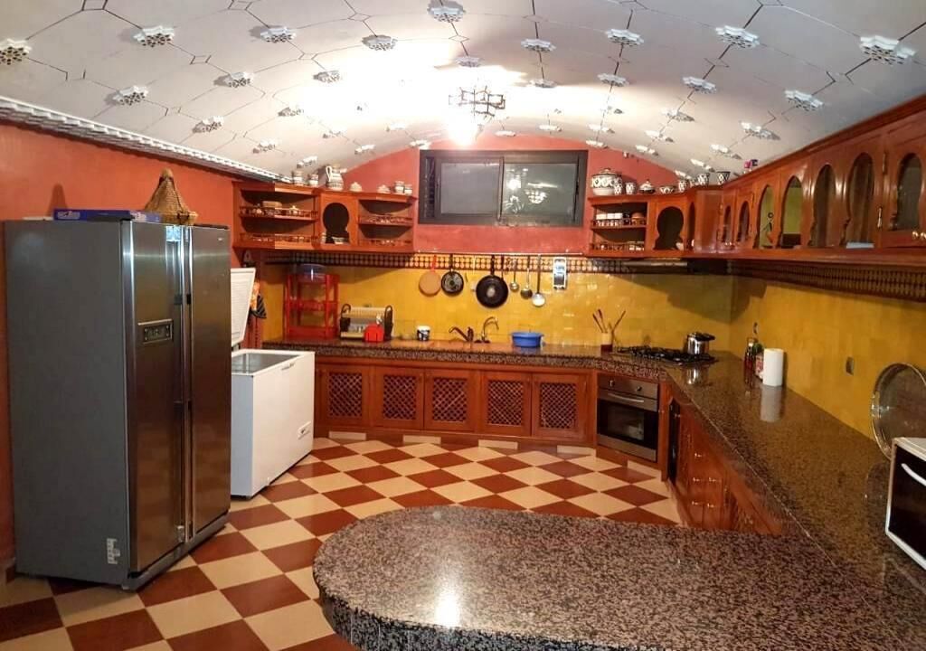 A kitchen with a checkered floor, a refrigerator, and wooden cabinets.