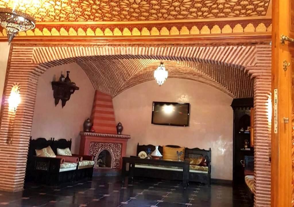 A room with a high arched ceiling, a fireplace, and two sofas.