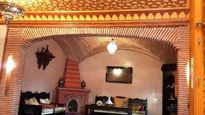 Ein Raum mit einer hohen gewölbten Decke, einem Kamin und zwei Sofas.