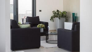 Un salon moderne avec un coin repas, comprenant un ensemble de canapés, une table basse et une table à manger avec des éléments pour le petit-déjeuner.