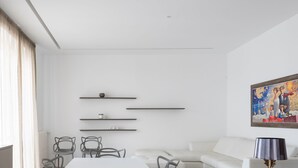A modern living room with a flat-screen TV, a sofa, a dining table with chairs, and a painting on the wall. - Design e Comfort nel centro di Catania by Wonderful Italy (Catania)