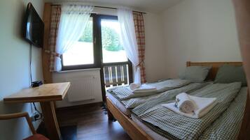 Een slaapkamer met een bed, een bureau en een televisie.