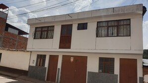 Un bâtiment à deux étages, doté d’un toit plat, de nombreuses fenêtres et d’une entrée fermée par un portail.