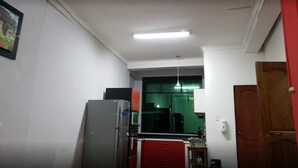 A compact kitchen with white walls, a refrigerator, a microwave, and a sink. - Casa Karmenka (Cusco)