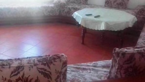 A living room with a round table, patterned sofas, and a red floor. - Jaharasmir Residence 2905 (Mdiq)