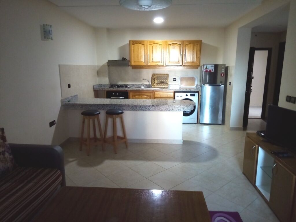 Een koelkast, een oven, een kookplaat, kookgerei, borden en bestek