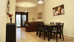 Un coin repas avec une table et des chaises, un canapé marron, une lampe et un tableau au mur.
