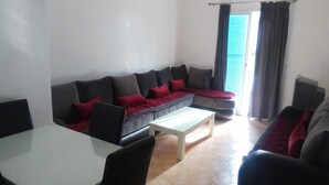 Una sala de estar con un sofá, una mesa de centro y una mesa de comedor.