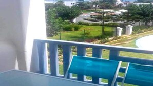 A balcony with a view of a landscaped garden and distant buildings. - Java Rasmile Residence 2906 (Mdiq)