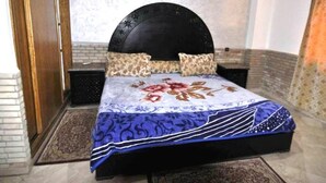 A bedroom with a bed, a headboard, a nightstand, and a wall-mounted light. - Residence Barrone Marrakech 3377 (Marrakech)