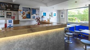 Un intérieur moderne avec un comptoir d’accueil, un ventilateur et une vue sur l’extérieur.