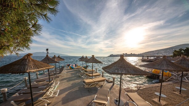 A beachside lounge with thatched umbrellas and sun loungers, overlooking the sea. - Hotel Jaroal (Sarandë)