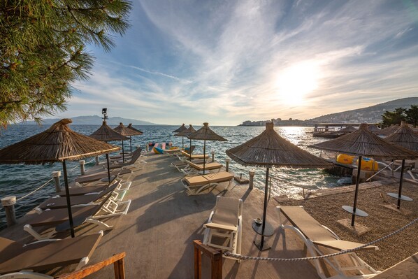 Yksityinen ranta, valkoista hiekkaa, aurinkotuoleja, aurinkovarjoja