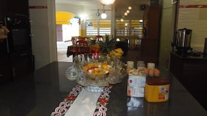 Una cocina con una isla central, un comedor al fondo y diversos electrodomésticos.