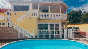 Un edificio de dos pisos con un balcón y una piscina.