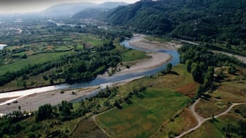A river winding through a valley with green fields and a road on the right.