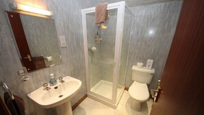 A bathroom with a glass-enclosed shower, a sink, a toilet, and a mirror. - Stronchreggan View Guest House (Fort William)