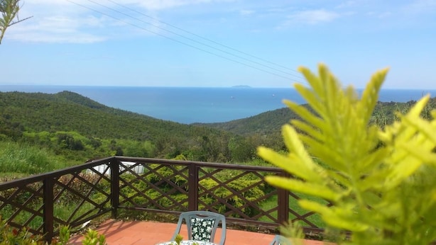A terrace with a view of the sea, a chair, and a railing. - Il Piccolo Paradiso (Livorno)