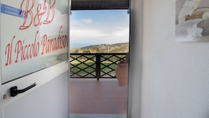 A door with a view of a balcony, a plaque with "B&B Il Piccolo Paradiso" text, and a potted plant. - Il Piccolo Paradiso (Livorno)