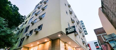 A multi-story hotel with a prominent entrance sign, balconies, and a modern architectural design.