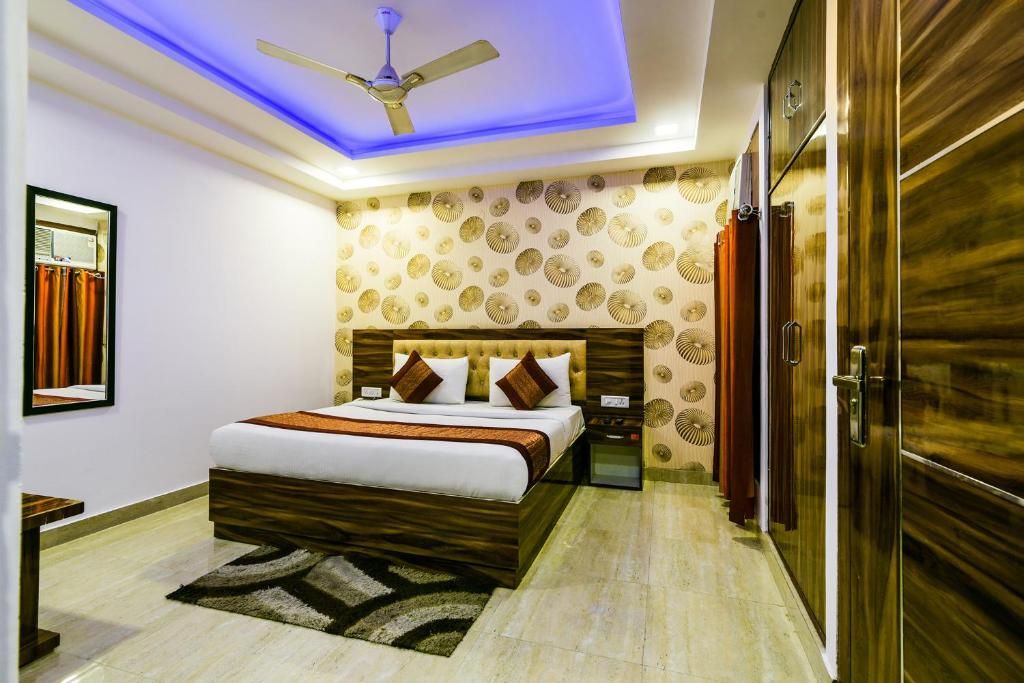 A bedroom with a bed, a ceiling fan, a nightstand, and a wardrobe.
