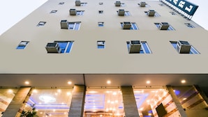 A hotel with multiple air conditioning units, a sign indicating the name, and a modern interior with a circular light fixture.