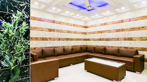 A modern lobby with a sectional sofa, a coffee table, and a potted plant.