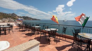 Une terrasse avec des sièges extérieurs et une vue sur la mer.