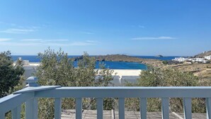 Une vue sur la côte, avec un ciel dégagé, une plage de sable et des bâtiments blancs.