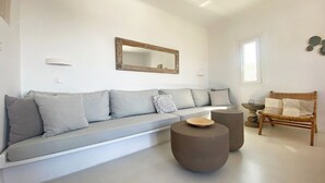 Un salon moderne avec un canapé gris, une table basse ronde et une chaise en bois.