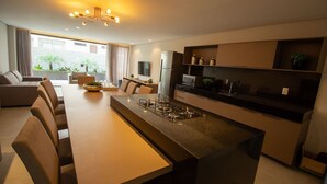 Une cuisine moderne avec un îlot central, un coin repas avec des chaises et un canapé.