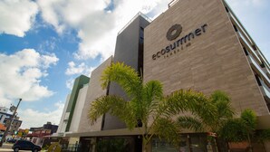 A modern building with the name 'ecosummer' on the facade, surrounded by palm trees. - Bela Hospedagem - EcoSummer Flats Tambaú (João Pessoa)