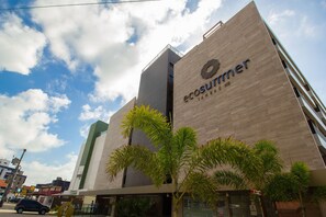 A modern building with the name 'ecosummer' on the facade, surrounded by palm trees. - Bela Hospedagem - EcoSummer Flats Tambaú (João Pessoa)