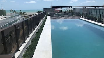 Una piscina en la azotea con vista a la playa y al océano.