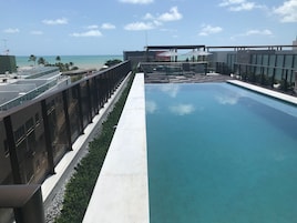 Una piscina sul tetto con vista sulla spiaggia e sull'oceano.