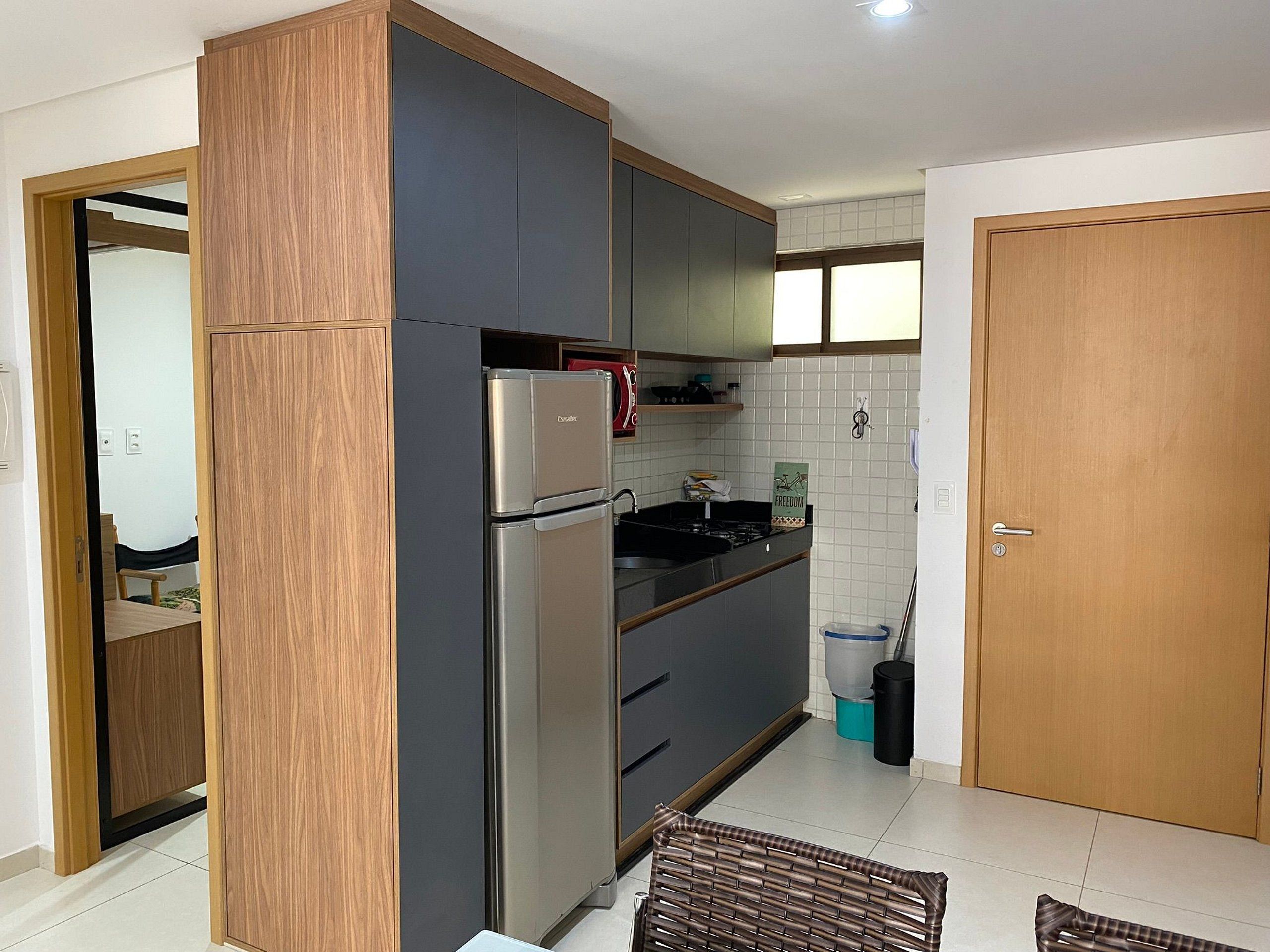 A kitchen with a refrigerator, stove, and cabinets.