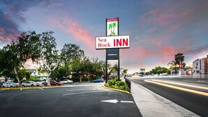 Une enseigne du Sea Rock Inn, avec un logo représentant un palmier, indiquant que l’établissement est situé en bord de mer.