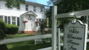 A white wooden fence with a sign that reads "White Blossom House Inn circa 1830."