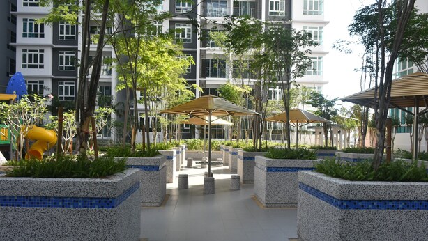 Une cour avec des jardinières, des parasols et un espace de jeux pour enfants.