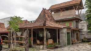 Una casa tradicional con techo de tejas, un porche y un patio con pavimento de piedra.