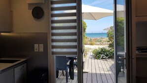 Una cocina moderna con vistas a una terraza de madera y al mar.