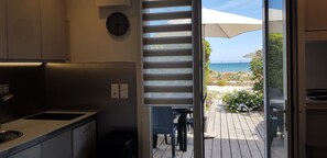 Una cucina moderna con vista su un pontile in legno e il mare.
